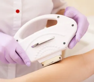 腕に脱毛機械を当てている様子